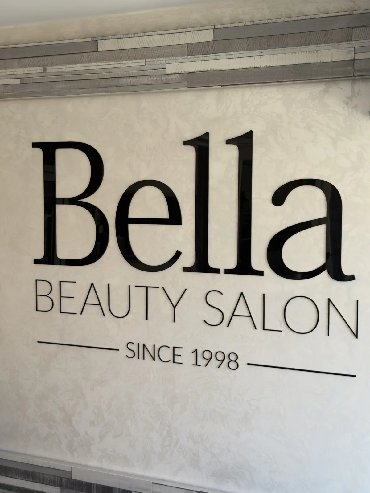 Знакът на Bella Beauty Salon от 1998 година на стената в салона в Дряново